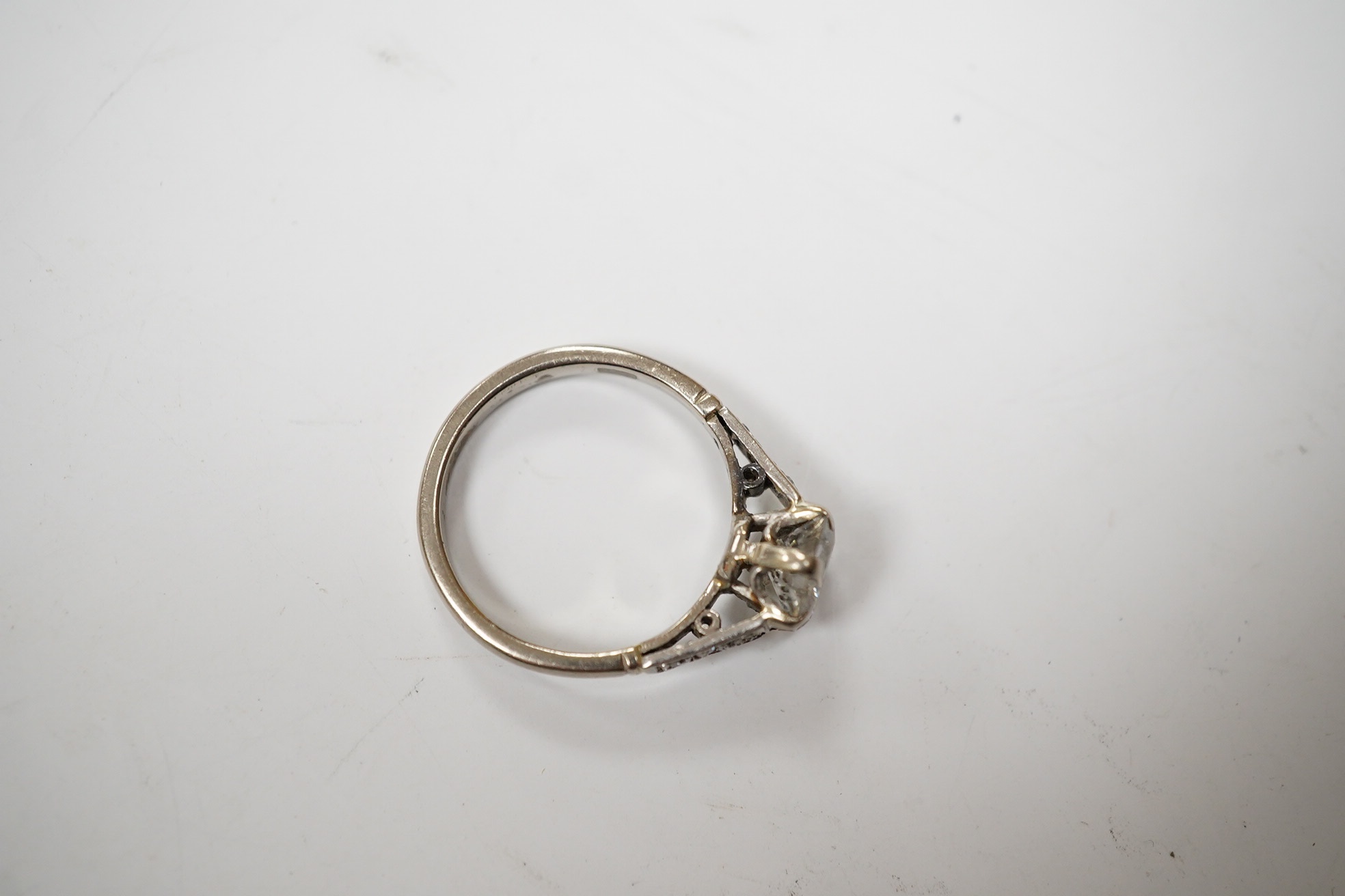 A white metal (stamped 18ct) and single stone diamond set ring, with six stone diamond set shoulders, the central stone weighing approximately 1.10ct, size M, gross weight 3.7 grams. Condition - poor to fair.